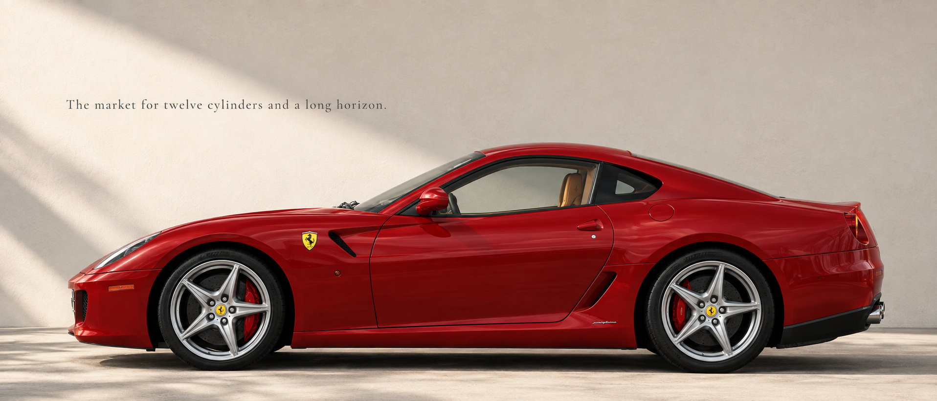 Red Ferrari 599 GTB in side profile beneath soft architectural light