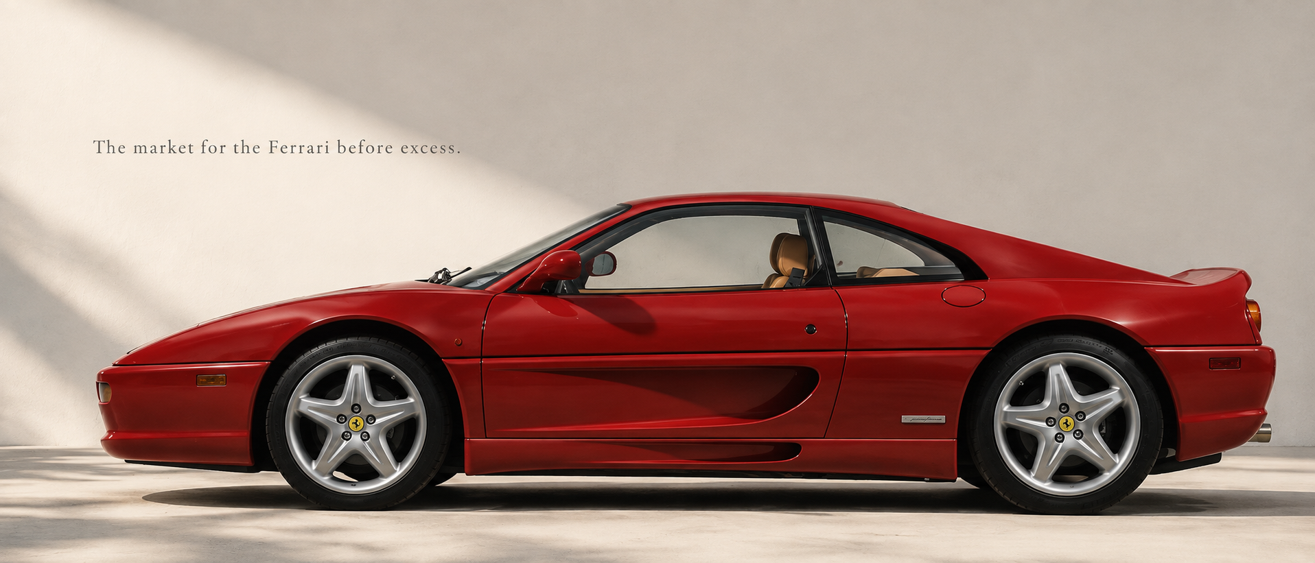 Red Ferrari F355 Berlinetta in side profile beneath soft architectural light