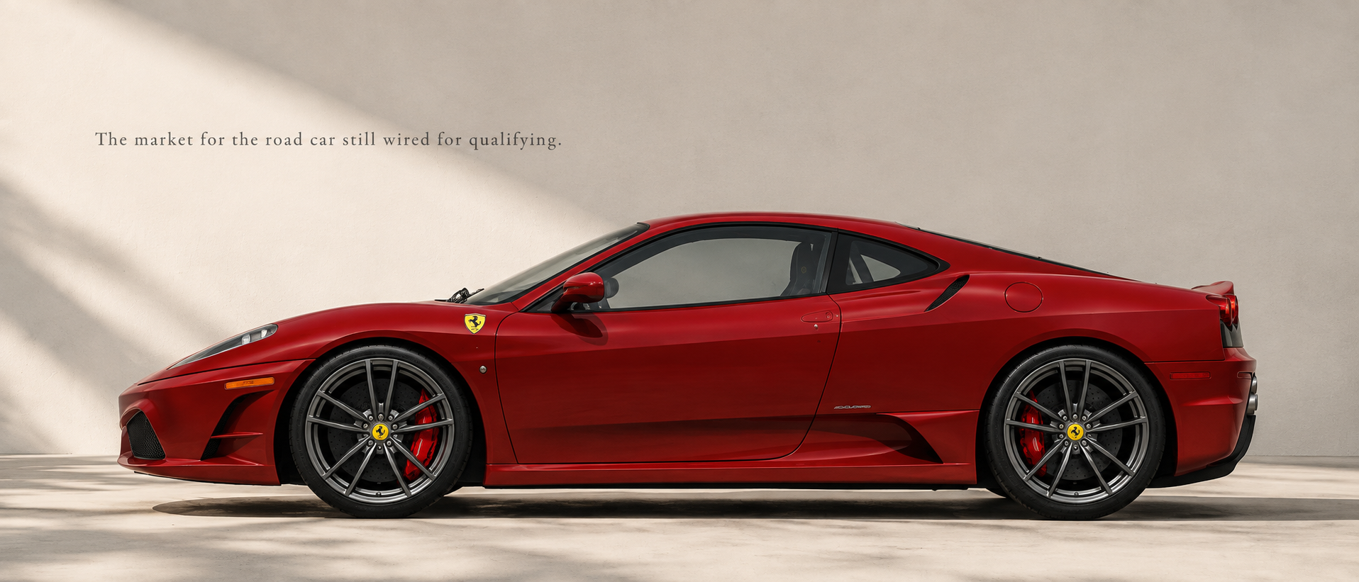Red Ferrari 430 Scuderia in side profile beneath soft architectural light